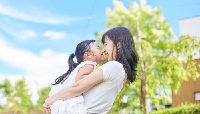 子どもと母親が抱き合って笑っている様子のイメージ