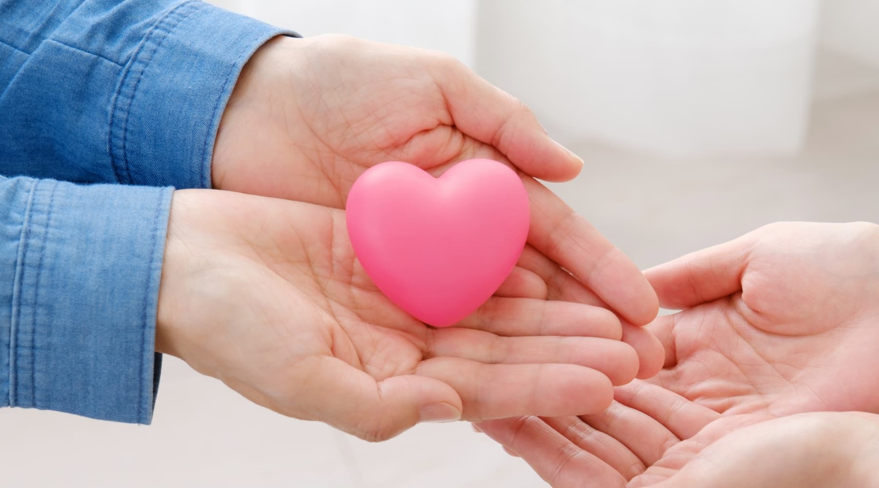 支援とつながりの想いを表現したハートを手渡すイメージ