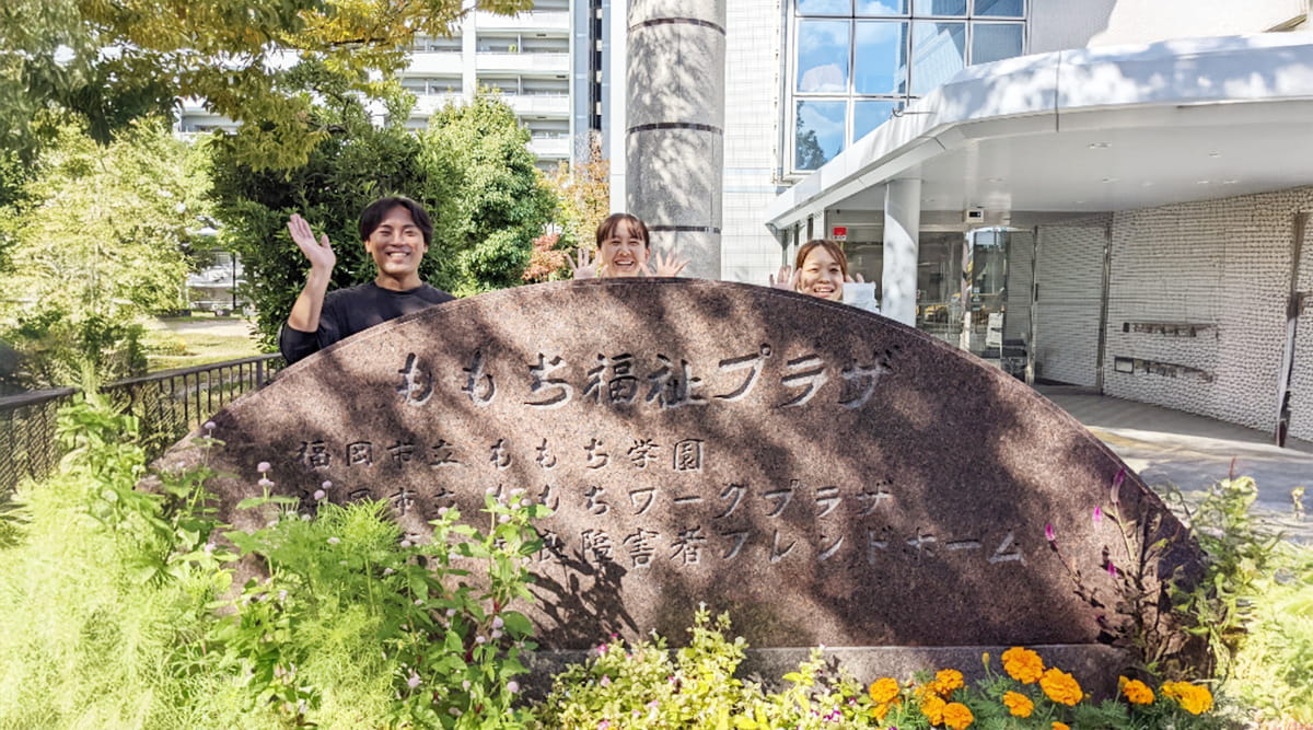 笑顔で手を振るスタッフ3人の写真